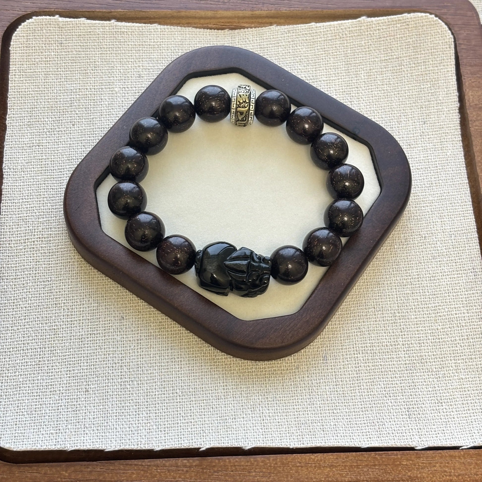 Men’s sandalwood bracelet with obsidian charm featuring golden accents and unique black zodiac beads.