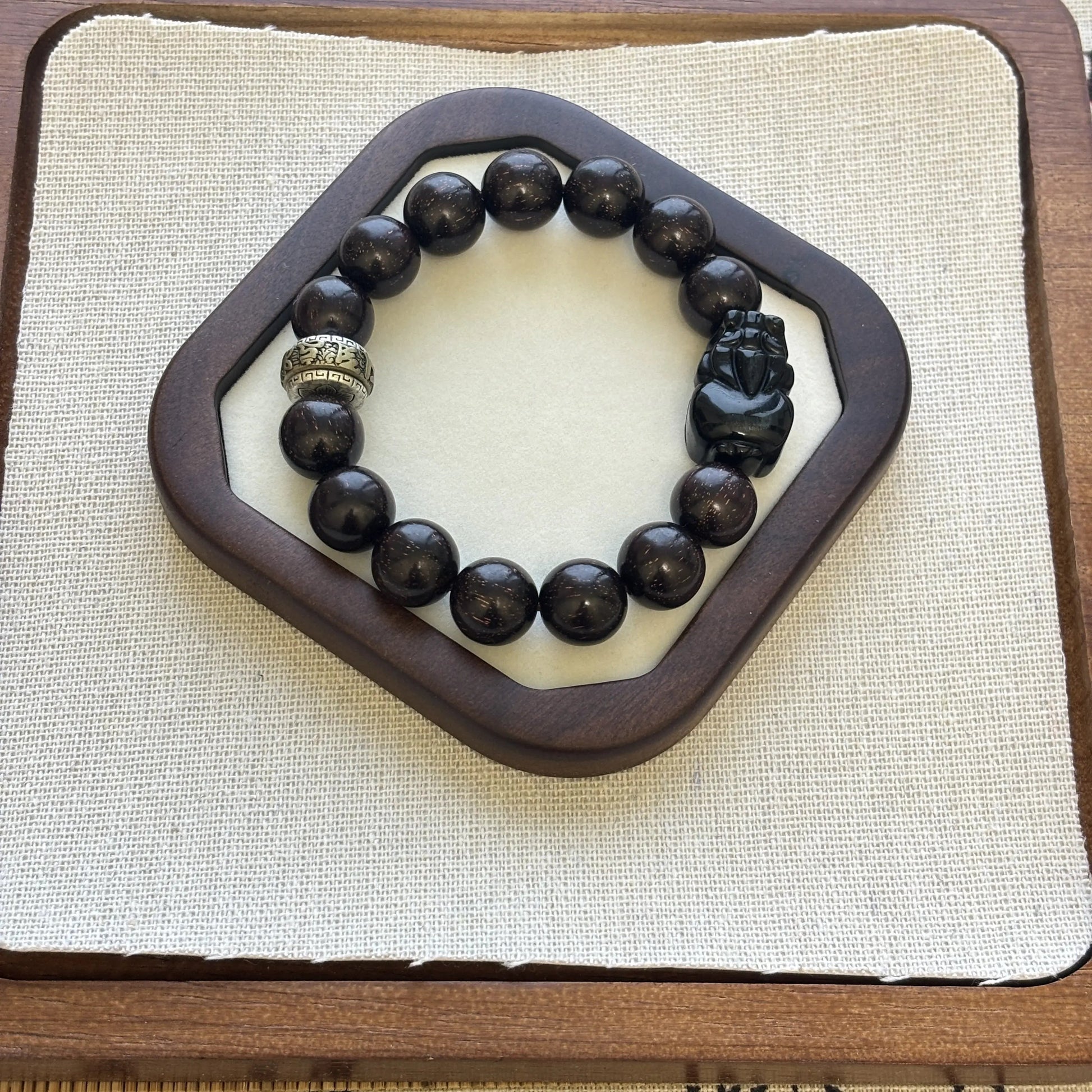 Men’s Sandalwood Bracelet with Obsidian Charm featuring golden accents and a unique design.