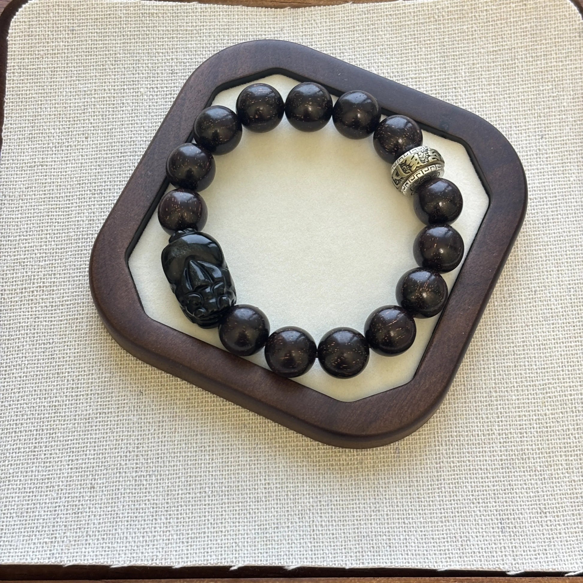Men’s Sandalwood Bracelet with Obsidian Charm featuring a skull and crown, elegant design for good luck and style.